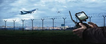 Drone and drone pilot with remote control at an airport Drone and drone pilot with remote control at an airport