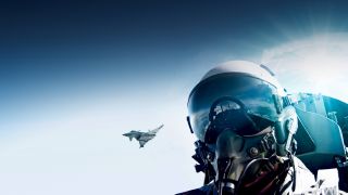 Head of a pilot within a helmet in front of the blue sky with a eurofighter in the background Head of a pilot within a helmet in front of the blue sky with a eurofighter in the background